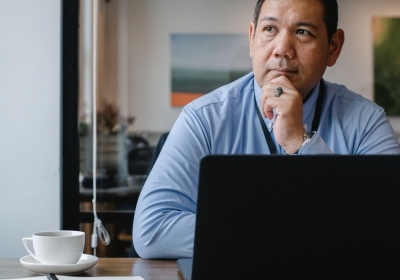 man denkt na achter zijn laptop